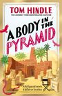 Das Cover zeigt den Titel "A Body in the Pyramid" von Tom Hindle. Rote und schwarze Schrift; Palmen, Skulpturen, Wüstenkulisse.