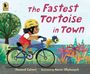 „The Fastest Tortoise in Town“. Kind mit Helm fährt Rad, Schildkröte im Korb. Buntes Laub und Baum sichtbar.