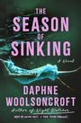 Text: "The Season of Sinking", "A Novel", "Daphne Woolsoncroft", "Author of Night Watcher", "Host of Going West: A True Crime Podcast." Eine Person schwebt im Wasser.