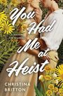 „You Had Me at Heist. A Season for Scandal. Christina Britton.“ Ein Paar steht zwischen gelben Blumen, innig vereint.