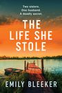 "Two sisters. One husband. A deadly secret. THE LIFE SHE STOLE. EMILY BLEEKER." Ein Steg ragt in einen ruhigen See bei Sonnenuntergang.