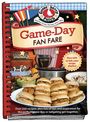 "Game-Day Fan Fare" in roter Schrift. Sandwiches, ein Slow Cooker und Salat auf einem gedeckten Tisch vor rotem Hintergrund.