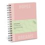 Text: "HOPES/DREAMS CUSTOMIZABLE JOURNAL". Ein rosafarbenes Ringbuch mit grünem Band, wellenförmigem Muster.