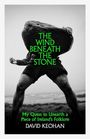 "The Wind Beneath the Stone. My Quest to Unearth a Piece of Ireland's Folklore. David Keohan." Person hebt großen Stein.