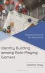 Text: "Slaying Goblins in the Real World", "Identity Building among Role-Playing Gamers", "Heather Shay". Mehrseitiges Spielthema, Würfel.