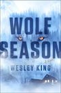 "WOLF SEASON, Wesley King, A Novel" in großen Buchstaben. Ein Wolfsgesicht in einem nebligen Wald mit einem Haus.