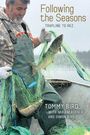 Text: "Following the Seasons: Trapline to Rez", "Tommy Bird with Miriam Körner and Simon Bird".  
Ein Mann in Anglerkleidung hält ein Netz mit Fischen.
