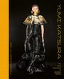 Text: "Yumi Katsura", "Cori and Kristin Coppola", "The Fairy Godmother of Japanese Fashion."  
Eine Person in avantgardistischer Mode.