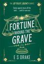 Text: "The Afterlife Agency Series. Some agents have all the luck... until it runs out. Fortune Favours the Grave. E S Drake." 
Illustration: Waagen mit Flügeln, Kleeblätter.