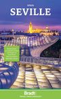 „Seville, Spain“ steht oben. Zitat über Reiseführerqualität. Abendaufnahme einer modernen Struktur und erleuchteter Stadt.