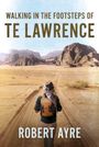 "Walking in the Footsteps of TE Lawrence. Robert Ayre." Ein Wanderer in der Wüste, im Hintergrund felsige Hügel.
