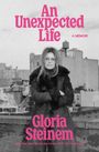Text: "An Unexpected Life - A Memoir - Gloria Steinem." Eine Frau steht mit verschränkten Armen vor einer städtischen Kulisse.