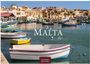 "MALTA 2027" und "CASARES EDITION". Ansicht eines Hafens mit bunten Booten und historischen Gebäuden im Hintergrund.