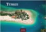 Großer Text "TÜRKEI", darunter Insel mit hellem Sandstrand und vielen Sonnenschirmen, Jahr "2027", im Wasser liegend.