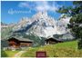 „Österreich“ und „2027 CASARES EDITION“; zwei Hütten vor eindrucksvollem Bergpanorama und grünem Hügel.