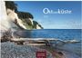 Text: "Ostseeküste 2027" und "CASARES EDITION". 
Strand mit Kieselsteinen und Treibholz, steile Klippen im Hintergrund.