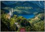 "Oberbayern 2027" in gelber Schrift. Eine Burg thront auf einem bewaldeten Hügel, dahinter ein blauer See und Berge.