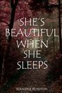 Text: "SHE'S BEAUTIFUL WHEN SHE SLEEPS" und "JENNIFER RUSHTON". Ein Waldweg mit Herbstfarben dominiert die Szenerie.