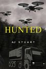 Der Text "HUNTED" ist groß und gelb. Darunter "AJ STUART" in Weiß. Drohnen fliegen über einen Wald, ein LKW ist unten sichtbar.