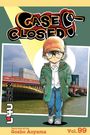 „Case Closed“, gezeichnete Figur mit Brille und Mütze, steht vor einer Brücke und Gebäuden.