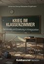 Titel: "Krieg im Klassenzimmer", Untertitel: "Demokratie und Erziehung in Kriegszeiten". Im Raum sind umgestürzte Tische und verstreute Papiere.