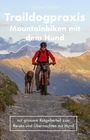 „Traildogpraxis: Mountainbiken mit dem Hund.“ Ein Radfahrer in roter Jacke fährt mit einem Hund auf einem Bergweg.