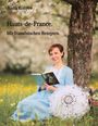 "Anna Konyev. Hauts-de-France. Mit französischen Rezepten." Frau in blauem Kleid liest unter einem Baum, neben einem Spitzen-Regenschirm.