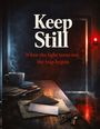 „Keep Still. When the light turns red, the trap begins." Ein Tisch mit Briefen, Schlüssel, dampfende Tasse; rotes Licht.