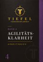 Band 4: Agilitätsklarheit Arbeitsbuch. Logo mit T und Kompass, dunkel mit lila und goldenen Akzenten.