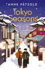 "Tokyo Seasons" prominent. Zwei Personen spazieren durch eine verschneite, festlich beleuchtete Straße, japanische Schriftzeichen auf Schildern.