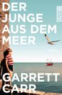 "DER JUNGE AUS DEM MEER", "GARRETT CARR", "ROMAN". Ein Junge steht an einer Felswand, nahe am Meer, eine Möwe fliegt.