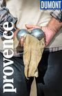„Provence“ steht vertikal, darüber „DUMONT Reise-Taschenbuch“. Zwei Hände halten Boulekugeln mit einem Tuch.