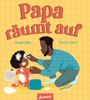 „Papa räumt auf“ steht groß. Ein Vater säubert ein Kind mit Mehl auf der Kleidung. Der Boden ist mit Mehl bedeckt.
