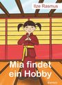 „Ilze Rasmus“ oben, „Mia findet ein Hobby“ unten. Illustration eines Mädchens in Karatekleidung, lächelnd in einem Dojo.