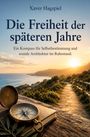 „Die Freiheit der späteren Jahre“ von Xaver Hagspiel. Ein Kompass auf einem Buch bei Sonnenuntergang mit Küstenweg.
