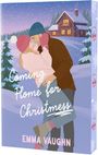Text: "Coming Home for Christmas" und "Emma Vaughn". Illustration: Ein Paar in winterlicher Landschaft, Schneefall, Blockhütte im Hintergrund.