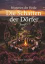 Text: "Mysterien der Heide: Die Schatten der Dörfer, Band 3. Helmut Wegner." 
Szene: Menschen bei einem Lagerfeuer, umgeben von Fachwerkhäusern und Heide.