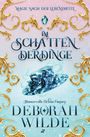 „Magie nach der Lebensmitte. Im Schatten der Dinge. Humorvolle Urban Fantasy. Deborah Wilde.“ Verziert mit goldenen Ornamenten.