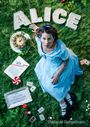 "ALICE" aus Kuchenbuchstaben, Schachbrett, Frau im blauen Kleid auf Gras mit Karten, Uhrkuchen, Buch und Früchten.