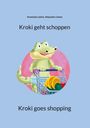 Text: „Kroki geht shoppen“, „Kroki goes shopping“. Illustration: Fröhliches Krokodil mit Einkaufswagen voller Lebensmittel.