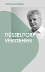 Text oben: "CHRISTIAN BACHMANN". Text in der Mitte: "DÜSSELDORF VERSTEHEN". Schwarz-weiß Porträt eines Mannes rechts.