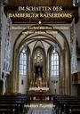 Text: "Im Schatten des Bamberger Kaiserdoms. Bambergs Kirchen aus dem Mittelalter und der Frühen Neuzeit. Johannes Bayerlein." 

Beschreibung: Innenraum einer Kirche mit Altar und Bänken.