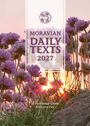 Texte: "MORAVIAN DAILY TEXTS 2027" und "A Devotional Guide for Every Day". Lila Blumen vor einem Sonnenuntergang.