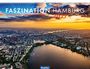 Faszination Hamburg 2027. Fotografiert von Martin Elsen. Luftaufnahme einer Stadt bei Sonnenuntergang, mit Wasserflächen und Gebäuden.