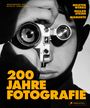 "200 Jahre Fotografie" in großer gelber Schrift. Schwarz-weiß-Foto einer Person, die durch eine Kamera schaut.