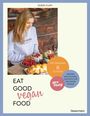 "DORIS FLURY. Eat Good Vegan Food. Mit maximal 6 Zutaten. Gesund und alltagstauglich für die ganze Familie." Eine Frau mit langen Haaren bereitet Essen an einem Tisch mit frischen Zutaten.