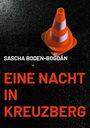 "Sascha Boden-Bogdán. Eine Nacht in Kreuzberg." Ein rot-weißer Verkehrskegel auf nassem Asphalt.