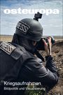 "Kriegaufnahmen. Bildpolitik und Visualisierung." Ein Fotograf mit Helm und Presseweste kniet in einem Graben mit Kamera.