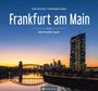„Frankfurt am Main“ in großer, weißer Schrift; städtische Skyline bei Sonnenuntergang mit einem Fluss im Vordergrund.