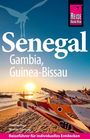 "Senegal, Gambia, Guinea-Bissau. Thomas Baur, Werner Gartung. Reiseführer für individuelles Entdecken."zeigt bemalte Boote am Strand bei Sonnenuntergang.
